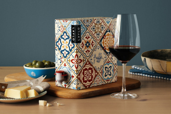 Glass of red wine next to an ornately decorated box