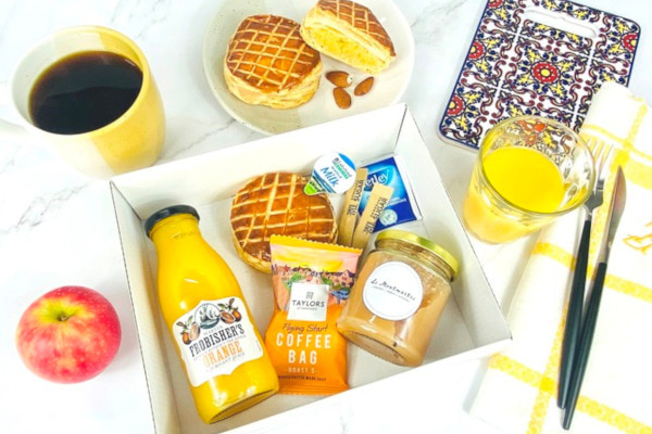 Breakfast box filled with juice, pastry, coffee, and more
