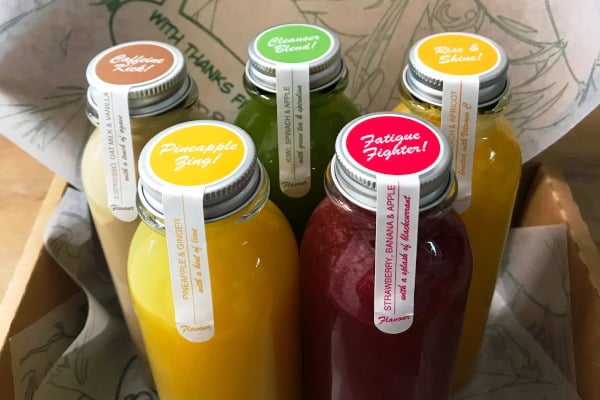 five colourful juice bottles in a cardboard box